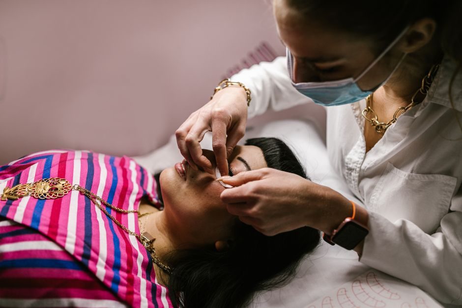 A technician threading a client's eyebrows
