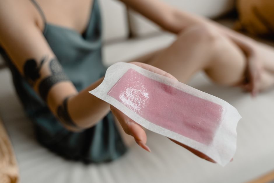 A hand holding a wax strip